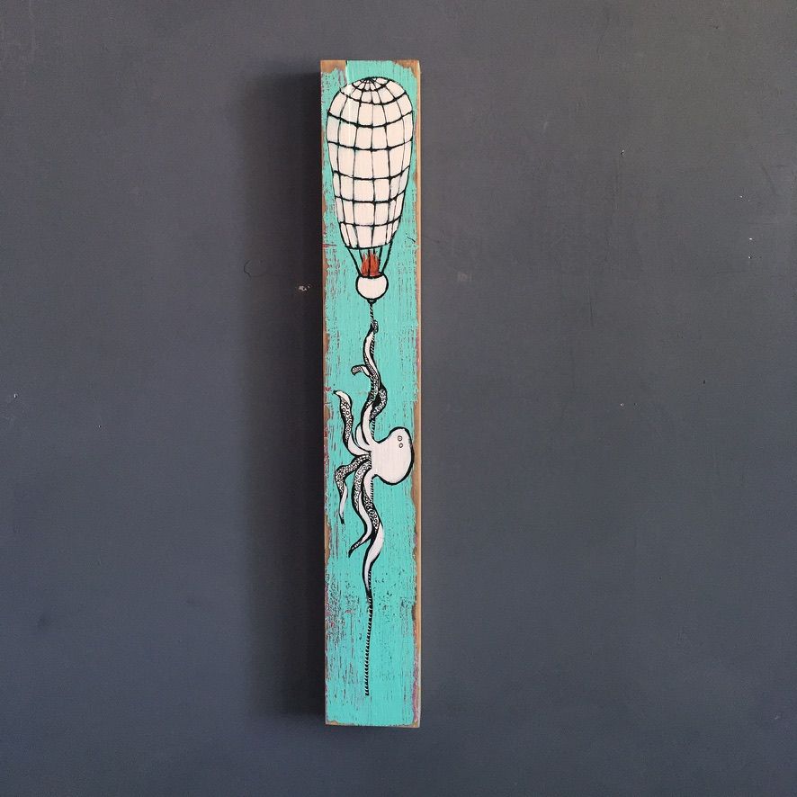 Mixed media painting on a tall narrow piece of found wood showing a white octopus dangling from a hand-sewn hot air balloon on a turquoise background.