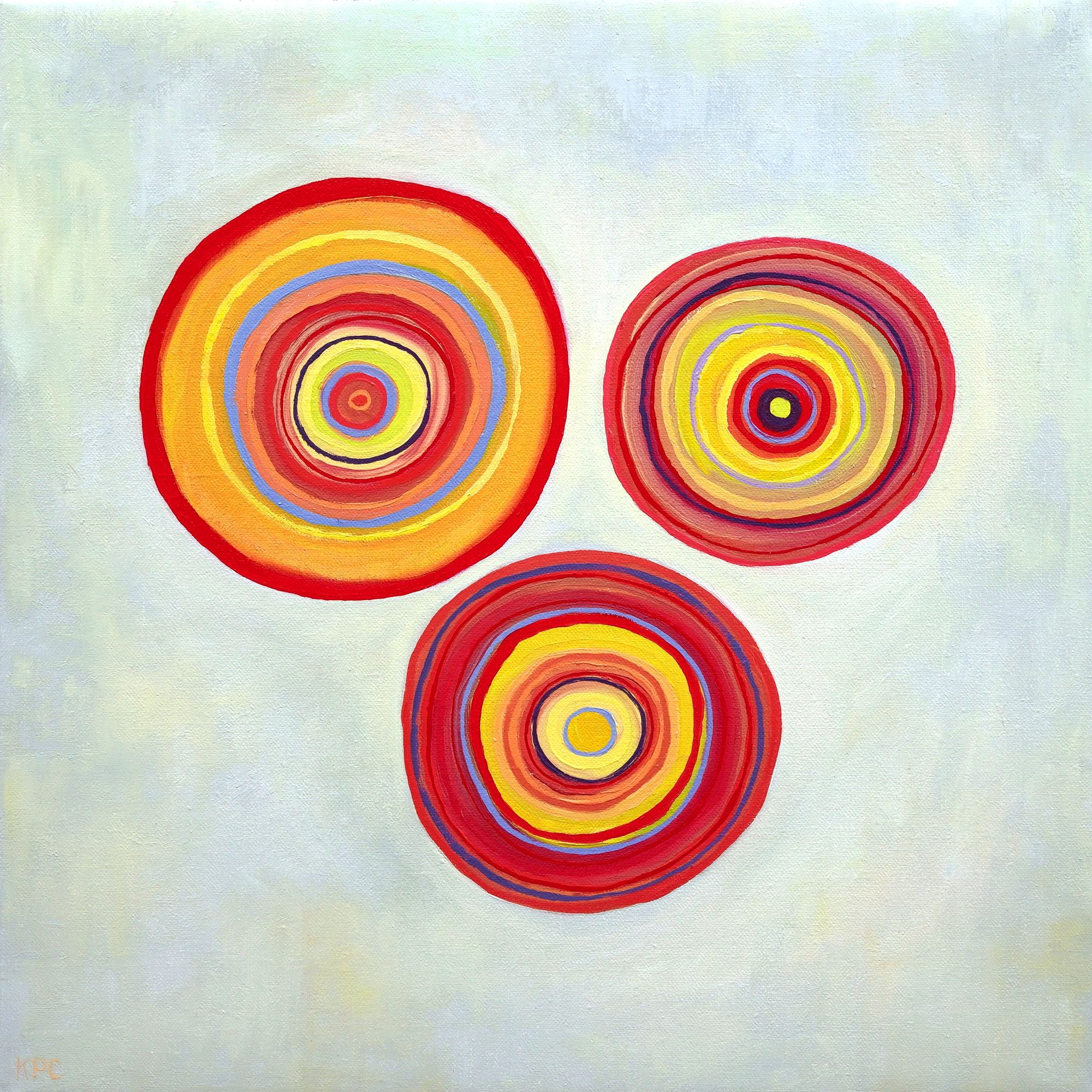 Oil painting of three concentric circle forms floating on a pale gray-green background, each composed of layered rings in warm reds, oranges, yellows, and accents of blue, evoking orbital patterns or cross-sections of sedimentary stone.