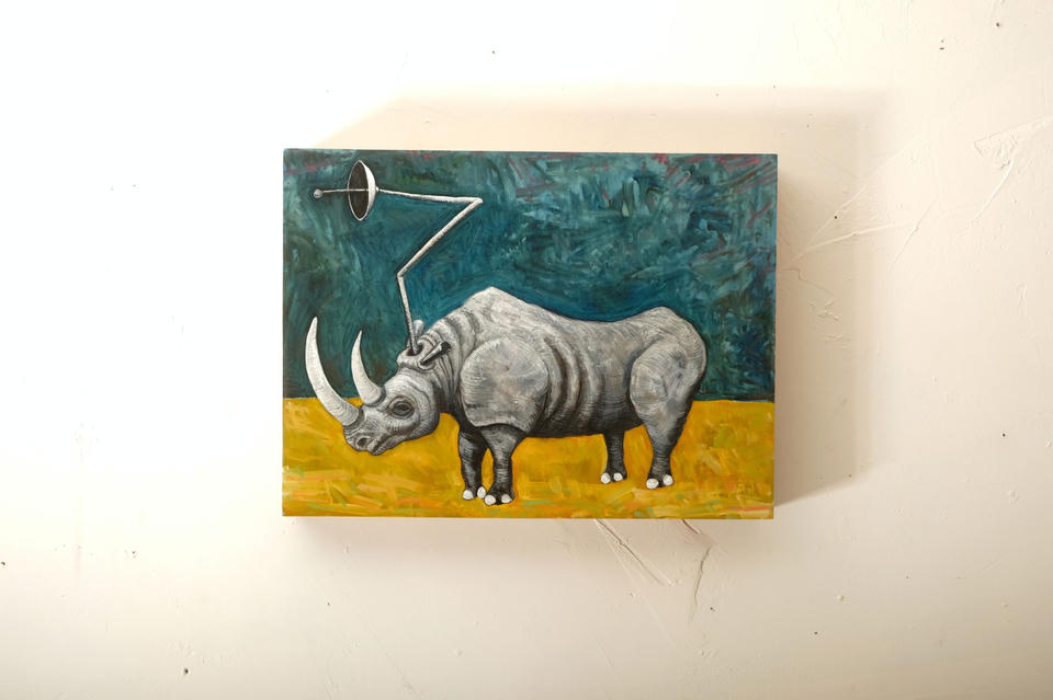 Oil on gesso panel painting of a gray rhinoceros with a satellite dish antenna mounted on its back, standing on yellow ground against an expressive teal-green background.