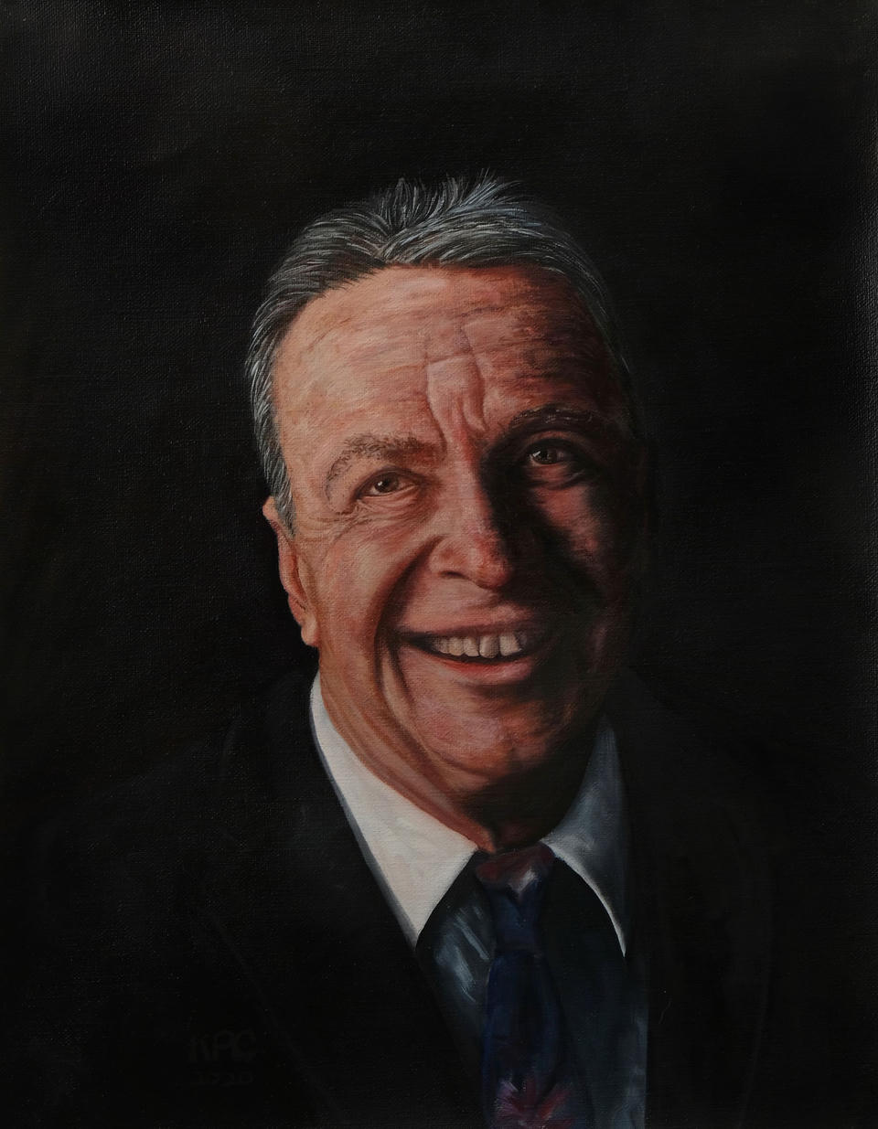 Oil on linen portrait of a smiling older man with gray hair, wearing a dark suit and colorful tie, warmly lit from one side against a black background.